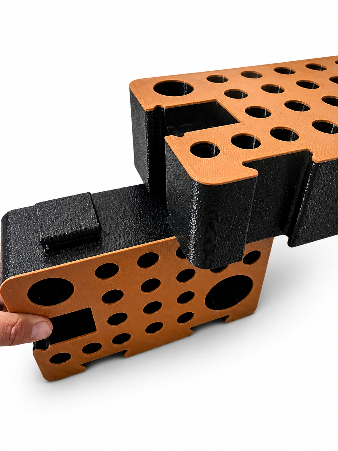 Hands separating two D-Blocks, showing the tongue-and-groove locking joint
